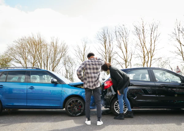 Two people looking at a car wreck