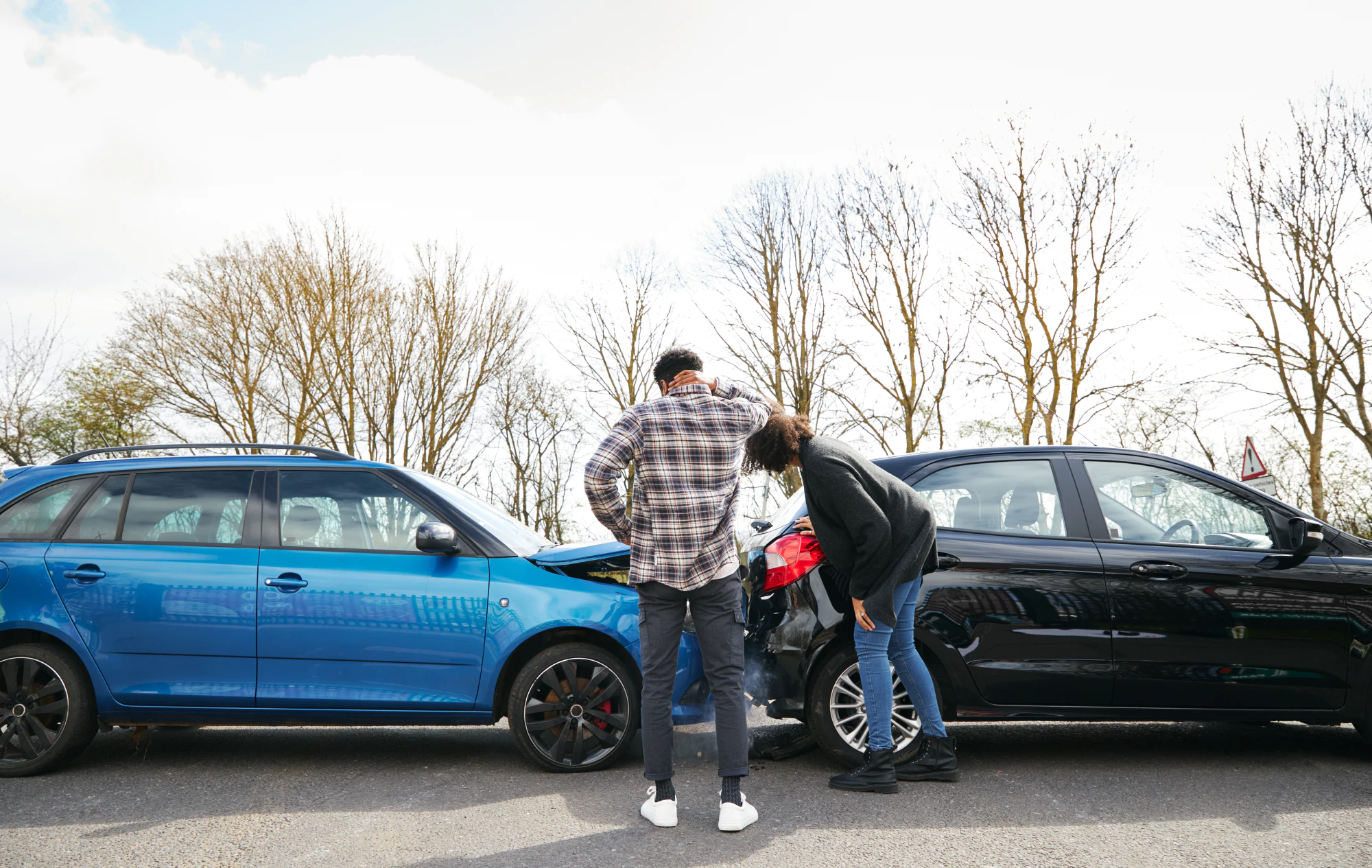 Two people looking at a car wreck