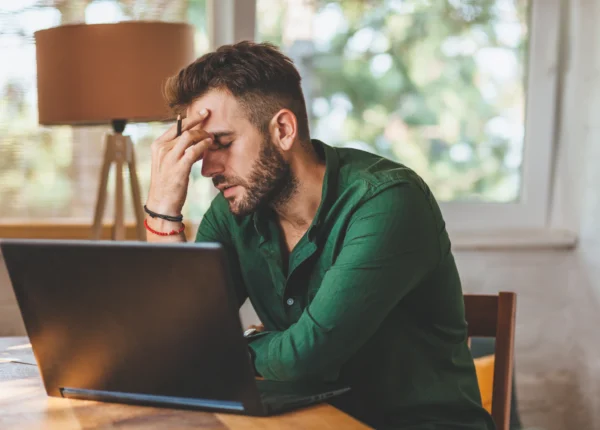 Frustrated young man sitting at laptop