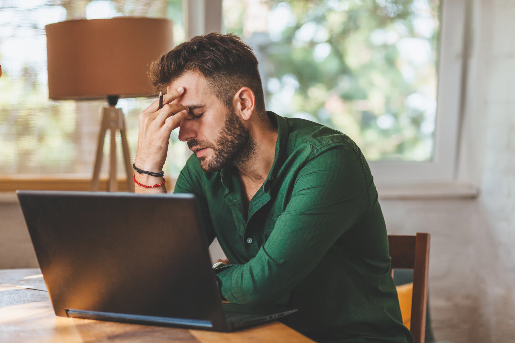 Frustrated young man sitting at laptop