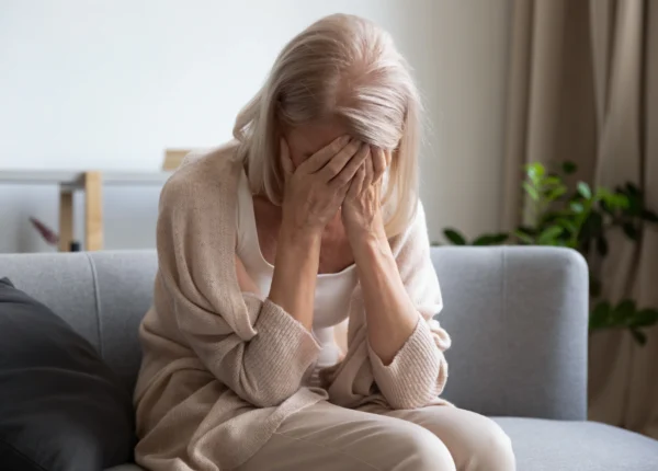 Older woman in distress on the couch.