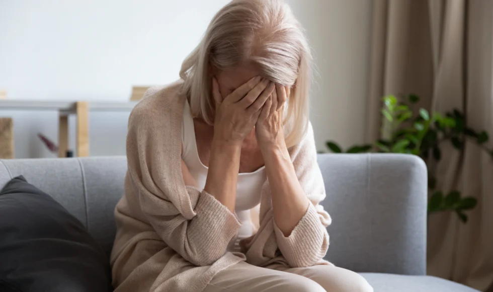Older woman in distress on the couch.