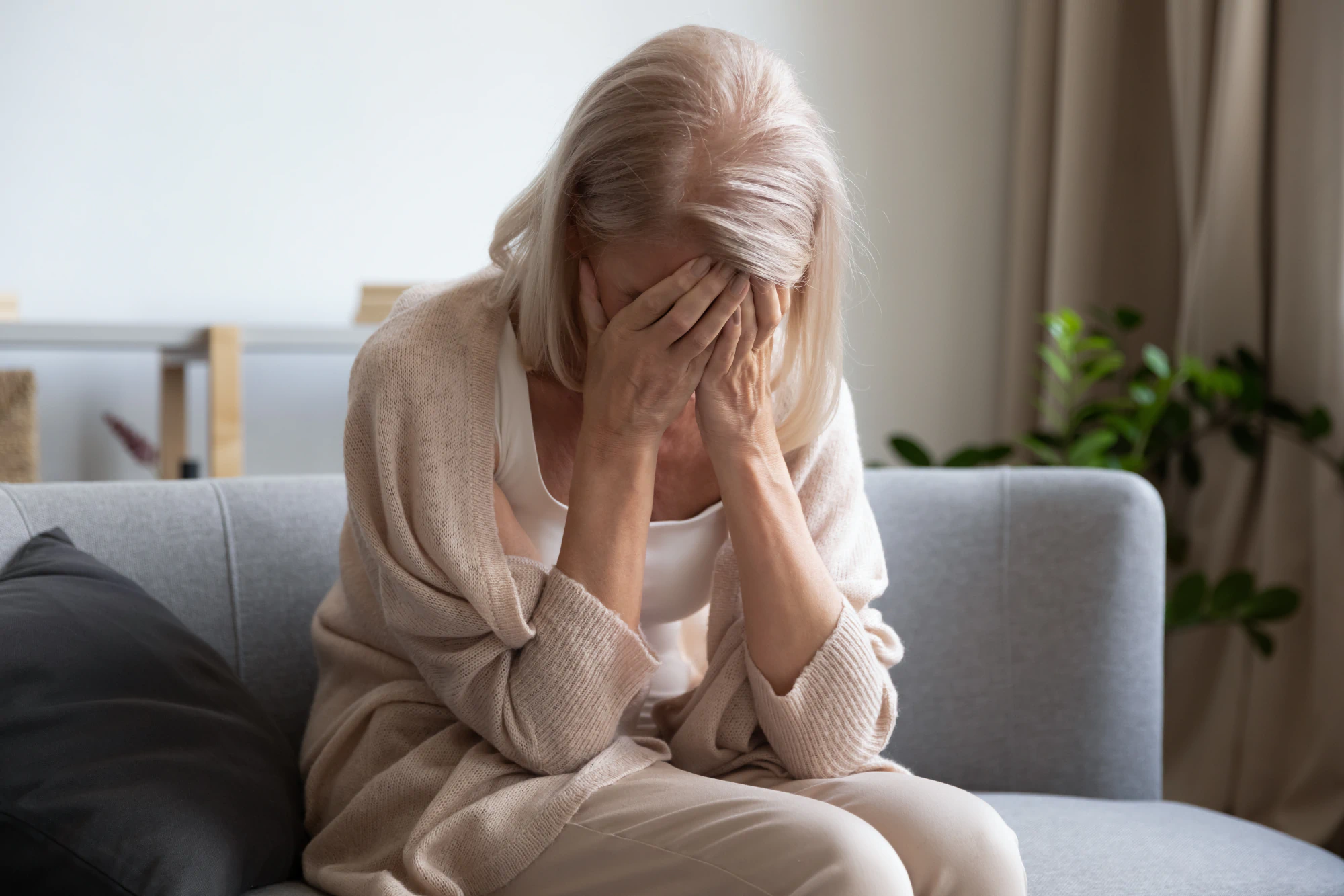 Older woman in distress on the couch.