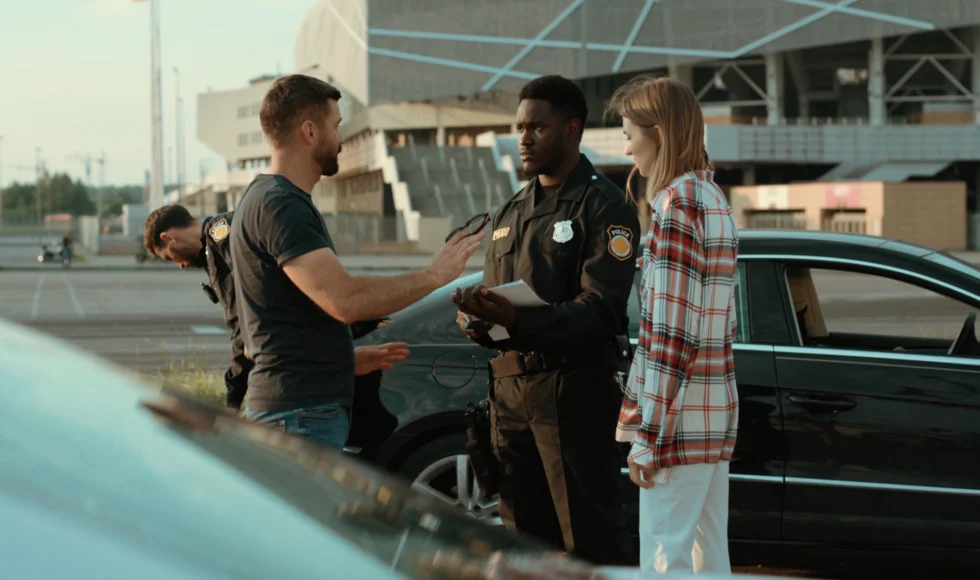 Couple talking to police officer at the scene of an accident.