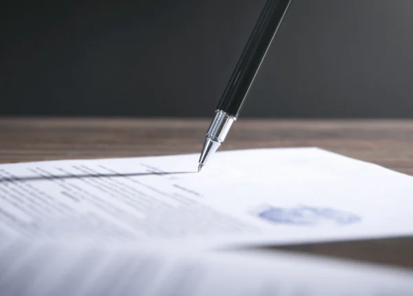 Silver-tipped pen signing an official document.