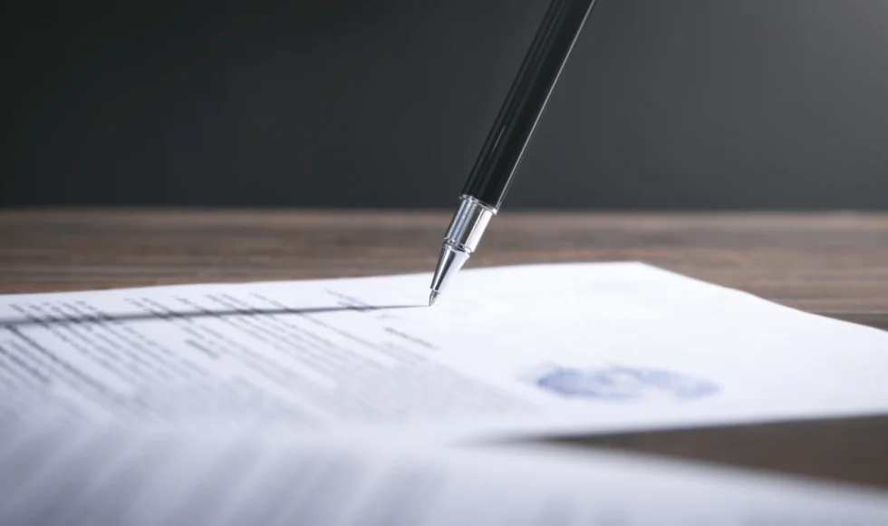 Silver-tipped pen signing an official document.