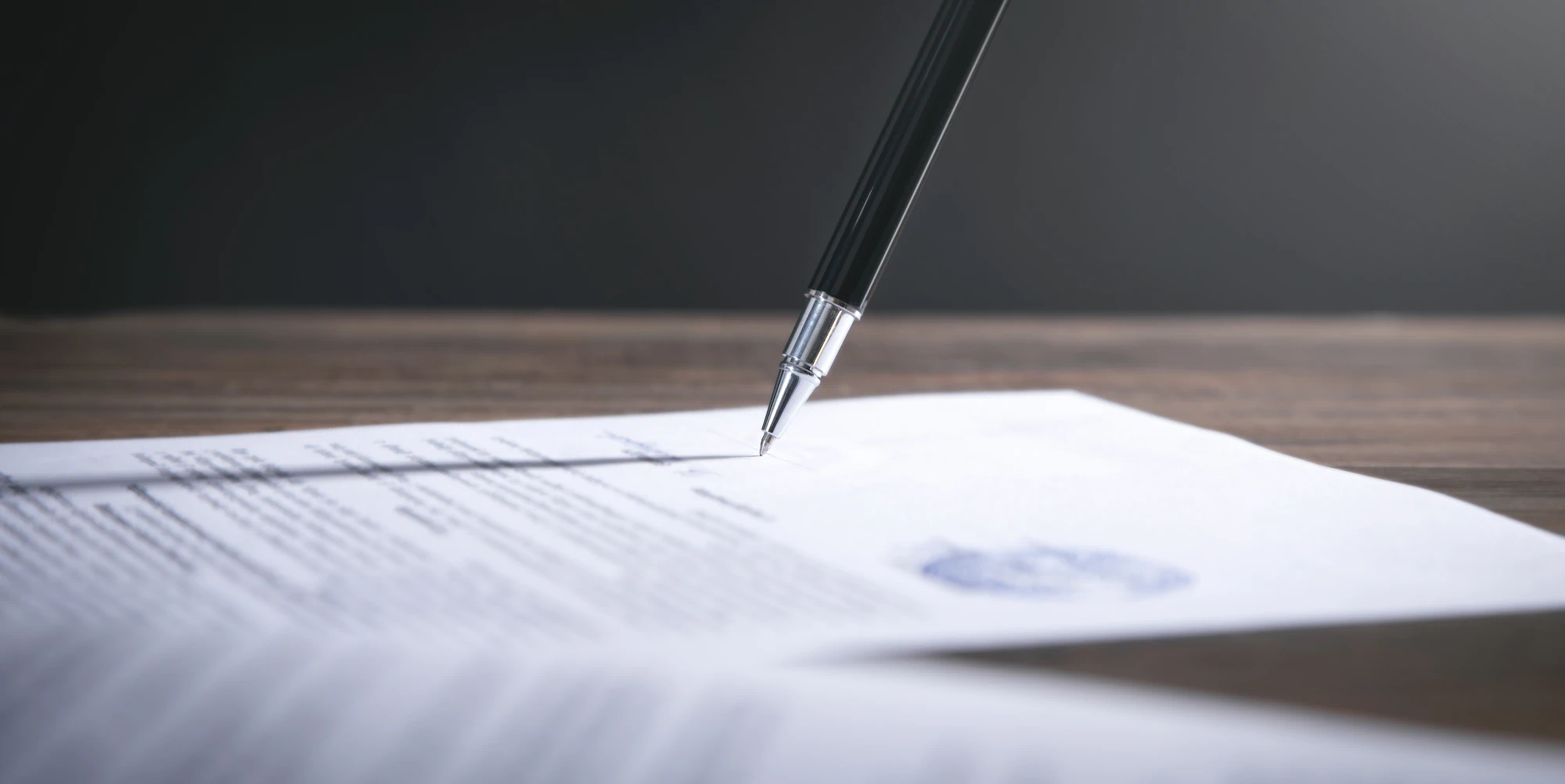 Silver-tipped pen signing an official document.