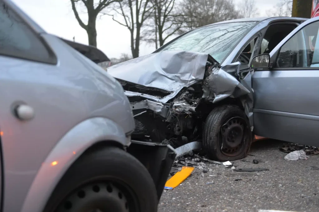 Two smashed grey cars after they collided head-on