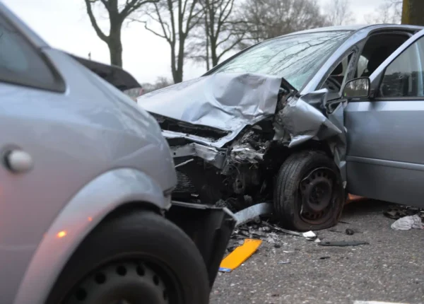 Two smashed grey cars after they collided head-on