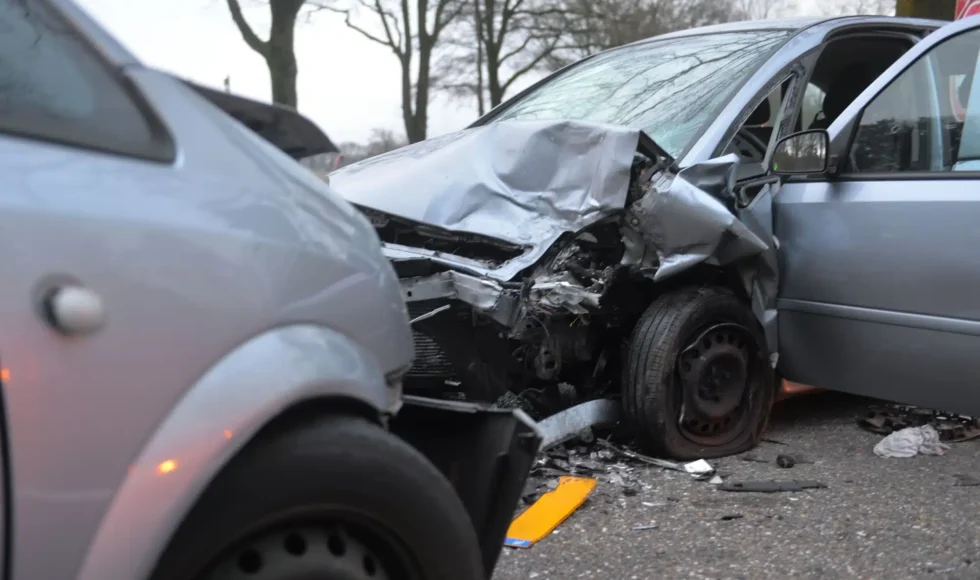 Two smashed grey cars after they collided head-on