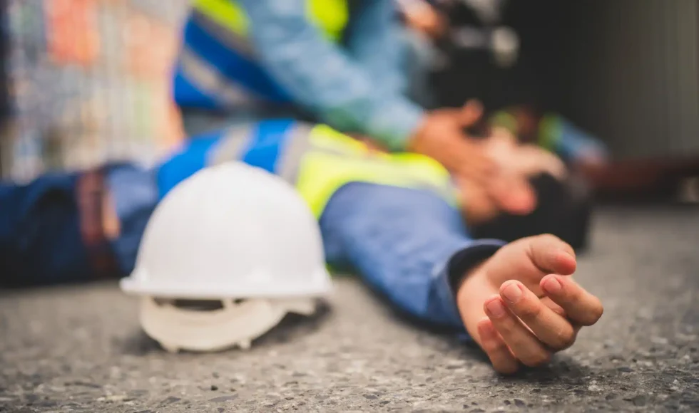 Construction worker lying on the ground with an injury